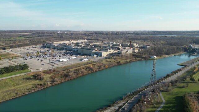 Aerial over the Welland Canal, St. Lawrence Seaway in St. Catharines, Ontario, Canada. Moving sideways right facing towards lock 5 in Thorold and Niagara Falls in the distance. Autumn, 2024.