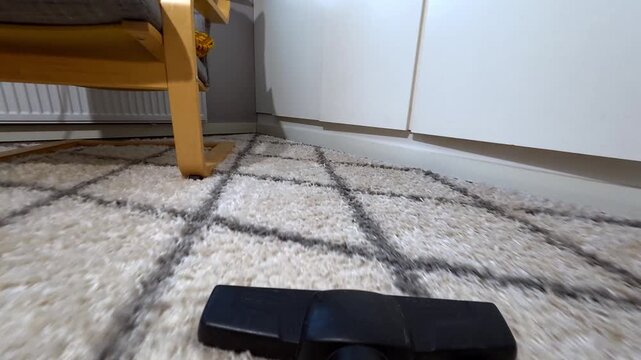 POV shot looking down vacuum cleaner hose cleaning dusty floor surface