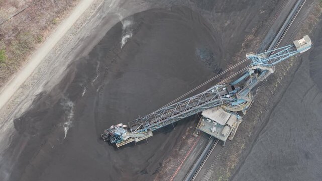 Aerial view of a stacker reclaimer machine processing coal in an open pit mine in South Kalimantan