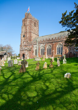 Red sandstone St Andrew's parish church in the village of Kenn, east Devon, England on a sunny spring day
