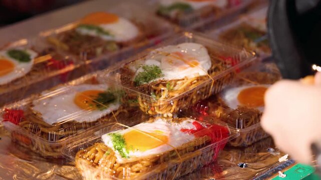 Yakisoba - popular Japanese Street Food, fried wheat noodles with bean sprouts and sauce cooking on a hot griddle with fried eggs, snack selection in Fukuoka, Japan, street market local vendors