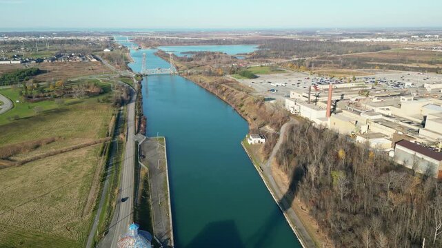 Aerial over the Welland Canal, part of the St. Lawrence Seaway in St. Catharines, Ontario, Canada. Lock 3, the Glendale Avenue lift bridge, Niagara-on-the-Lake and Lake Ontario. Autumn, 2024.