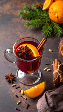 Ruby red mulled wine in transparent glass mug with orange star anise and cinnamon stick web banner.