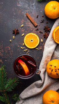 Ruby red mulled wine in transparent glass mug with orange star anise and cinnamon stick web banner.