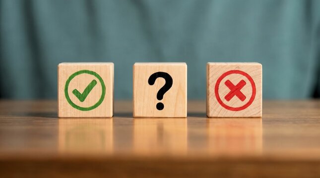Wooden blocks featuring check mark, question mark, and cross symbols lined up on brown table surface