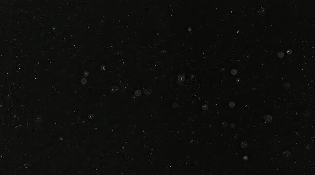 Abstract dark background with floating dust particles and bokeh light spots