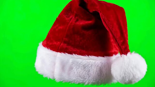 Classic red Santa hat with white fur trim floating on green screen
