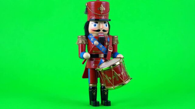 Wooden nutcracker soldier playing drum on green screen background
