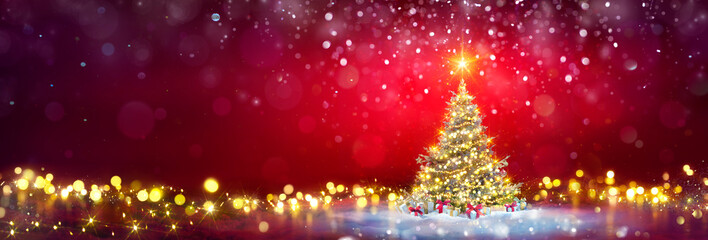 Christmas Tree In Red Background On Snow And Defocused Abstract Bokeh Lights © Romolo Tavani