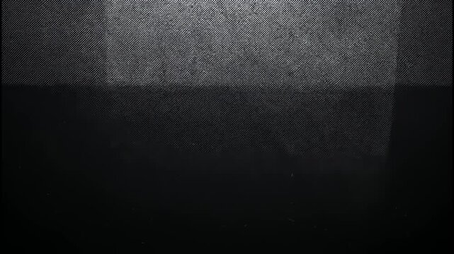 Dark textured background with a fine crosshatch pattern and soft atmospheric light 4k video