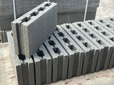 Stacked grey concrete hollow blocks on wooden pallet