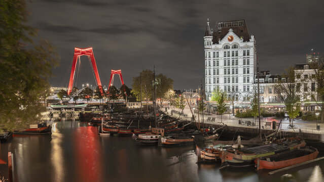 Historic boats moored in Oude Haven (old harbor) beneath Witte Huis in Rotterdam at night, ideal for travel themes
