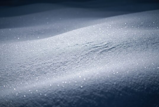 Close-up of soft snow texture with sparkling ice crystals in bright light