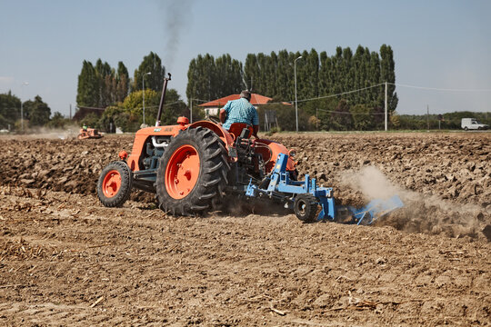 A farmer plowing the field with an old Fiat 80 R tractor (circa 1960) and a plow during the country fair