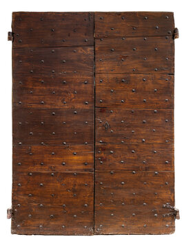 Antique double door made of dark rustic solid wood, reinforced with traditional decorative wrought iron studs and historical metal hinges. Isolated. 
