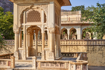 Ornate historical Indian pavilion constructed from sandstone featuring intricate architectural details including carved jali latticework screens, decorative floral motifs, and scalloped arches © Andrius