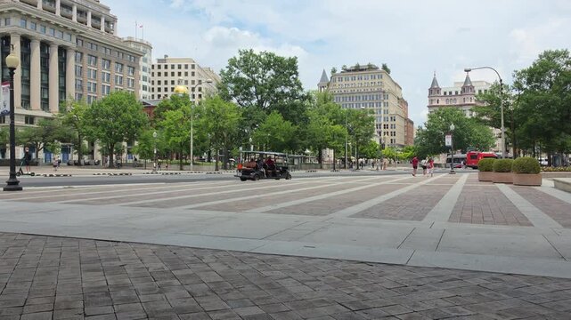 A broad paved plaza overlooks passing traffic and downtown Washington architecture in 4K video.