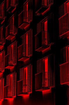 Graphic reworking  in thriller and horror style of the facade of a palace and balconies with a terrifying red light inside. Black and red colours, book cover, illustration, symbolic, poster