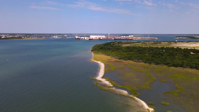 Marsh vegetation and pale sand border Radio Island as the port approaches ahead.