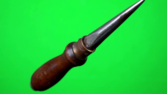 Vintage metal ice pick tool with wooden handle rotating over chroma key green screen background for digital editing
