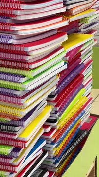 A large stack of colorful spiral notebooks and copybooks close up concept for back to school and office supplies