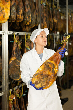 Young specialist at the factory inspects the ham during the process, checking the quality and ageing of the product.