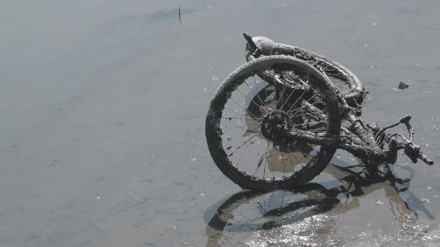 川に不法投棄された自転車のクローズアップ　環境問題と河川汚染