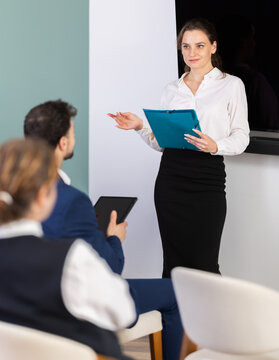 Female speaker gives lecture, uses paper document presentation materials shorthand dictation. Discussion of development strategy, crisis management