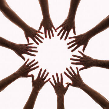 Diverse people joining hands in circle showing unity and teamwork