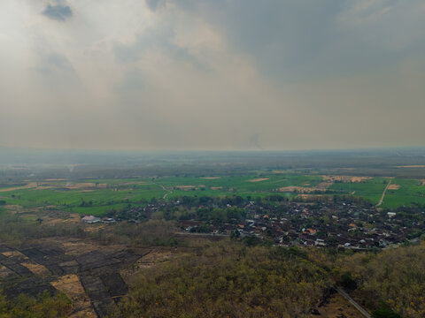 Aerial drone view of a rural village nestled among fields and dry teak forests in East Java Indonesia