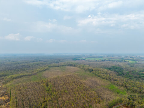 Aerial drone view of a rural village nestled among fields and dry teak forests in East Java Indonesia