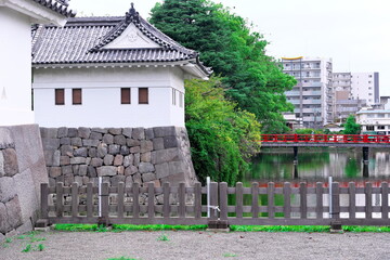 Japanese castle turret standing by moat with red bridge © taka