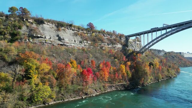 Niagara Gorge aerial from the Niagara River, the international border crossing Queenston-Lewiston bridge between New York, United States and Ontario, Canada. Autumn fall foliage tree leaves 2024.
