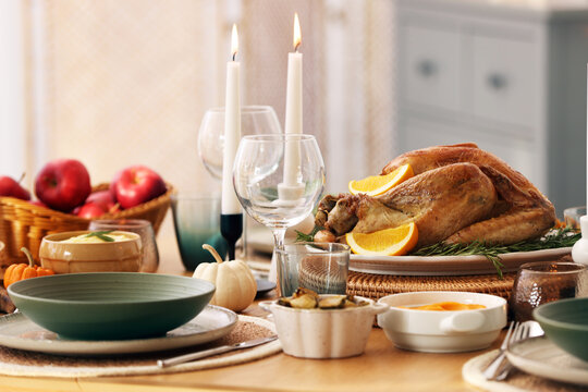 Happy Thanksgiving day. Festive dinner with delicious food and burning candles on wooden table indoors, closeup