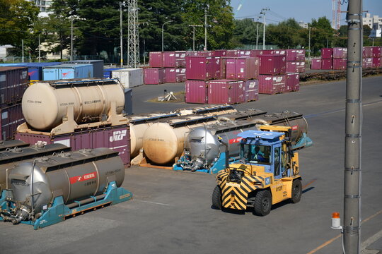 Yellow forklift and tank containers at a freight depot in Japan