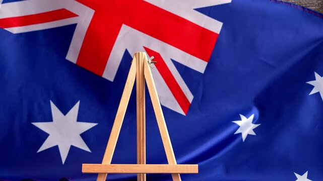 Somber Australian flag backdrop with text LEST WE FORGET on letter board. Respectful message for memorial ANZAC campaigns. Concept of remembrance and honor