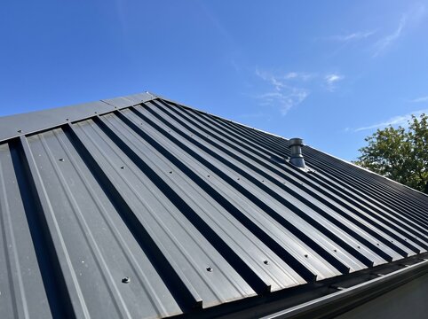 Modern grey metal roof panels on a residential house exterior against