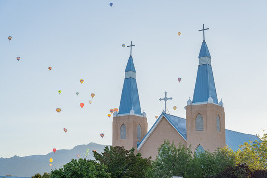 Church with blue spires and hot air balloons in sky