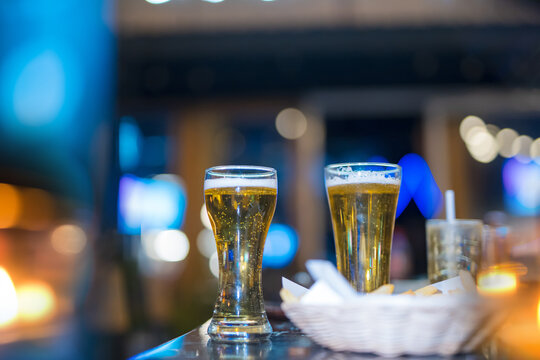 food and drink male friends are happy drinking beer and clinking glasses at a bar or pub.