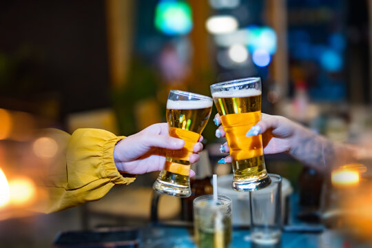 food and drink male friends are happy drinking beer and clinking glasses at a bar or pub.
