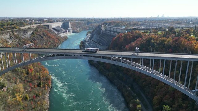 Aerial lowering over the Niagara River and international border crossing Queenston-Lewiston bridge between New York and Ontario, Canada with hydroelectrical power plants, autumn 2024.
