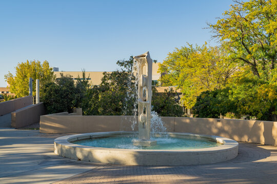Modern concrete fountain sculpture in circular pool