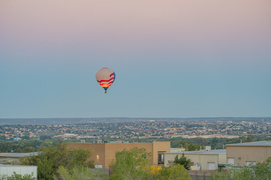 Hot air balloon floating above city skyline