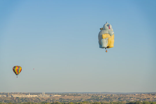 Hot air balloons floating over city skyline
