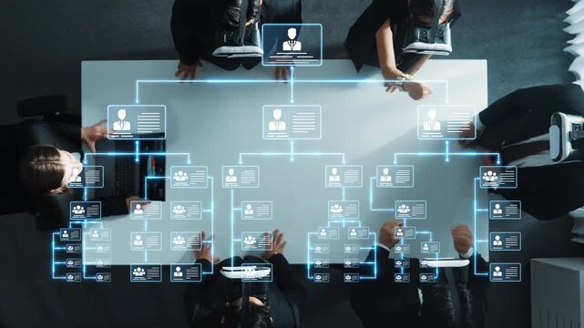 Aerial view of a professional business meeting showcasing digital interfaces displaying organizational charts and team profiles in a modern office setting. Raster