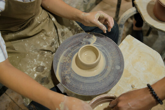 Close up of Artisan Molding Ceramic Vessel On Pottery Wheel Head