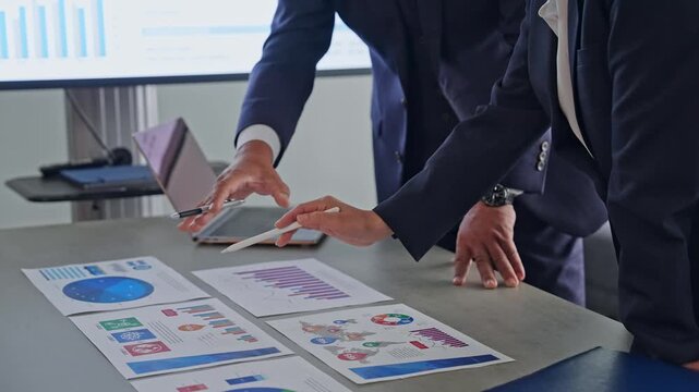 A group of business professionals conversing while looking at documents. Meeting, management, strategy, company, data, marketing
