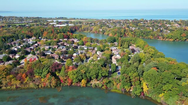 Aerial panning moving left over Martindale Pond viewing Richardson's Creek and Lake Ontario in north St. Catharines, Ontario, Canada on a sunny Autumn day in October, 2024.