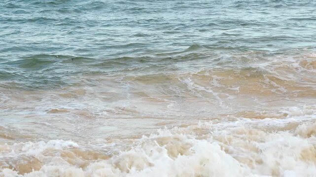 Slow motion ocean waves rolling onto a beach in Dar es Salaam Tanzania creating a peaceful tropical coastal scene.