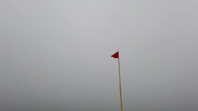 Hindu Om Flag Flying During Cyclone Rain Against Open Sky